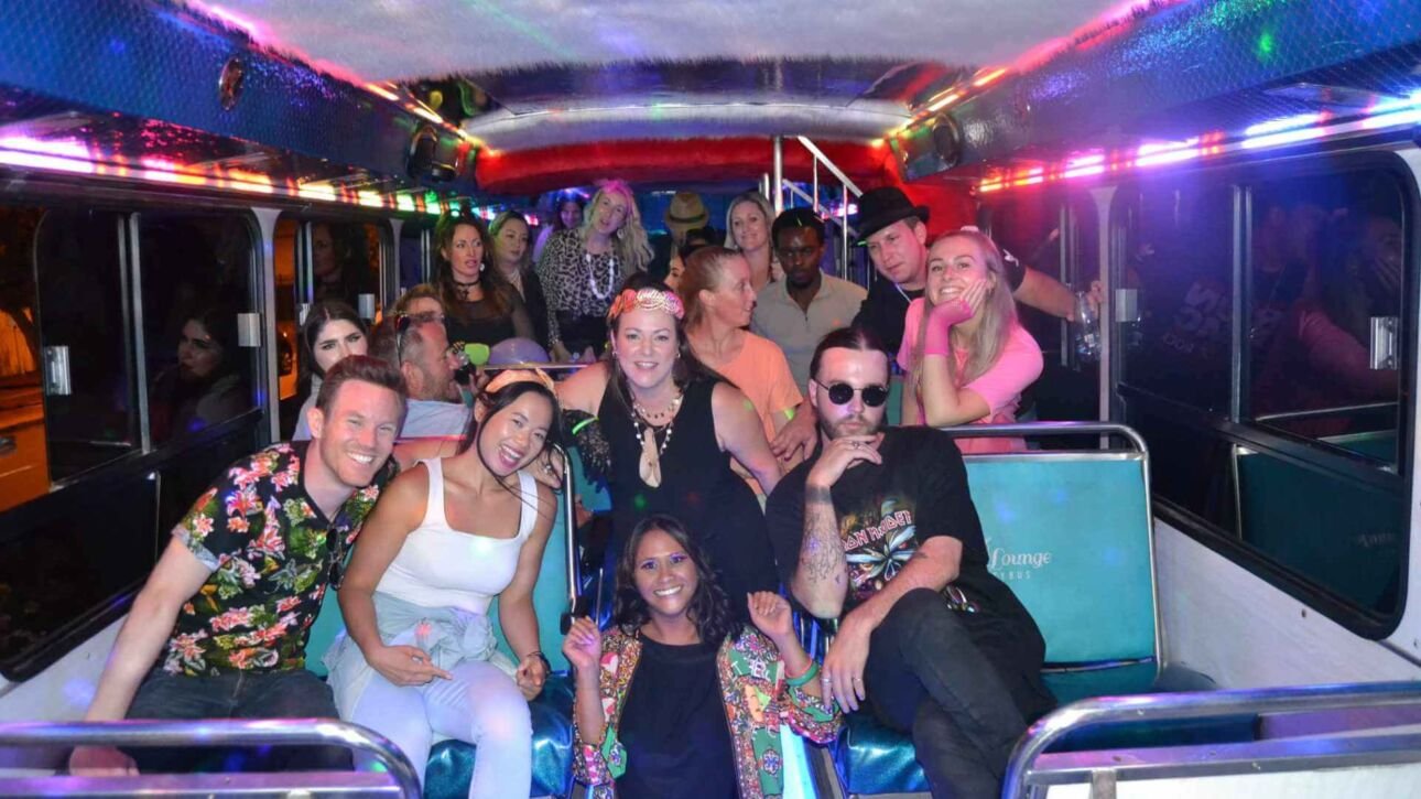 A large group of people posing inside a party bus during a party.